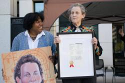 USPTO’s Director of Education and Outreach Joyce Ward presents Temple Grandin with an oversized copy of her inventor trading card and her livestock handling designs. USPTO Inventor Trading Cards aim to inspire children with stories of diverse inventors.