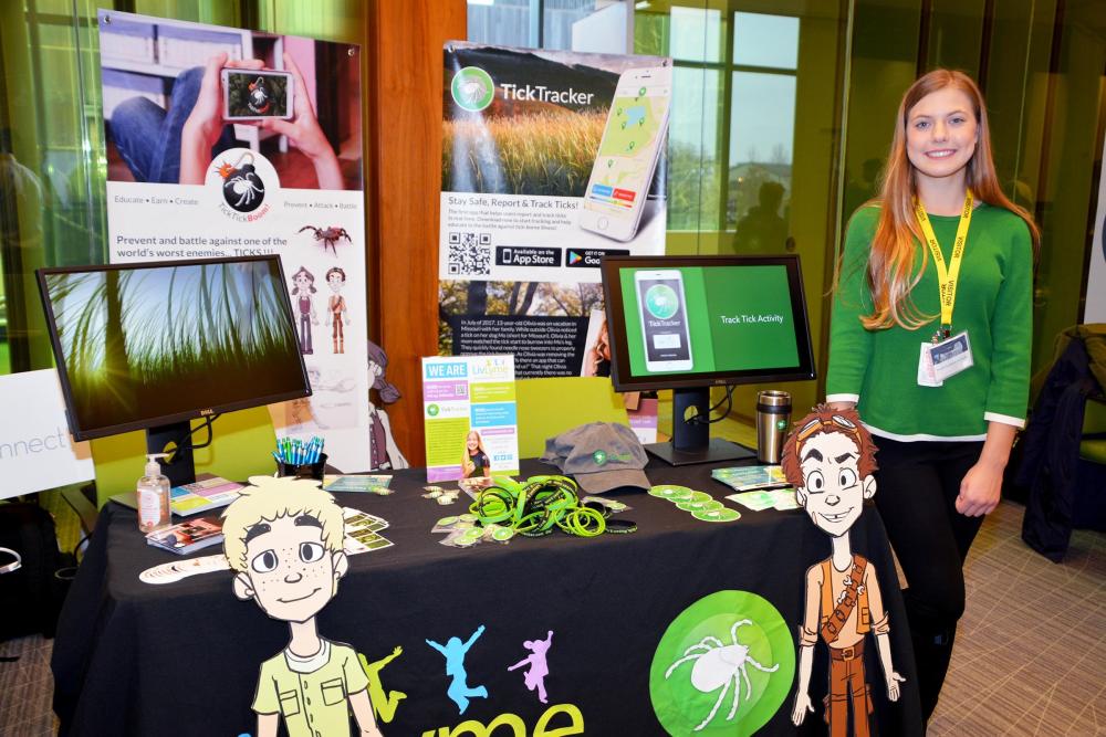 Olivia Goodreau stands with her live demo table for the app she invented, Tick Tracker, at The Opportunity Project Demo, 3/1/19.  Tick Tracker uses CDC and other federal data to provide heat maps of nearby ticks to prevent lyme disease. 