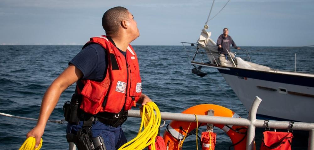 U.S. Coast Guardsman throws a roap to a stranded sailor during a rescue in the Gulf of Mexico on December 19, 2019. 