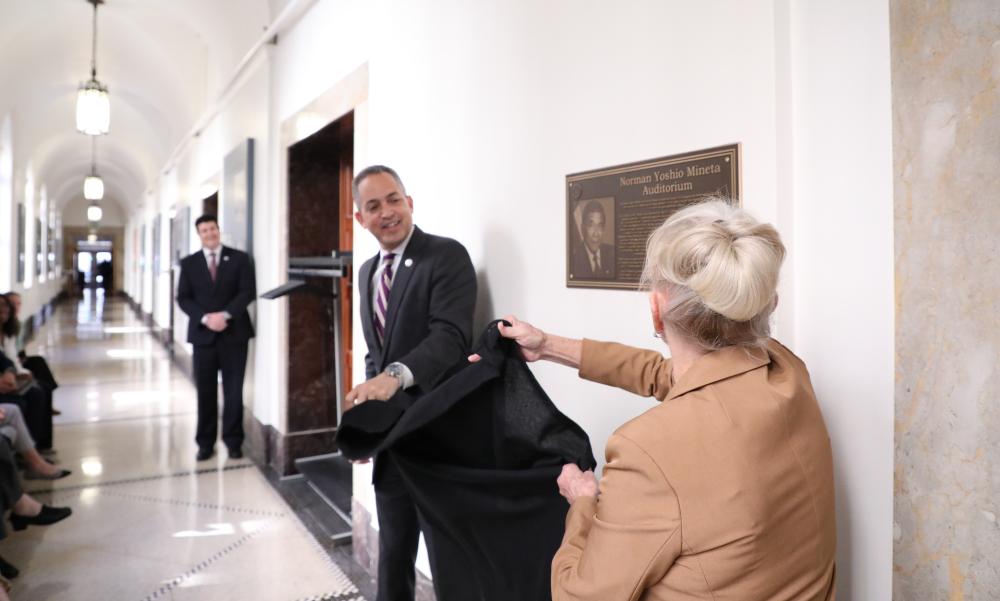 U.S. Deputy Secretary of Commerce Don Graves and Danealia Mineta unveil plaque of Norman Y. Mineta at a dedication ceremony naming the Commerce Department’s auditorium in his honor.