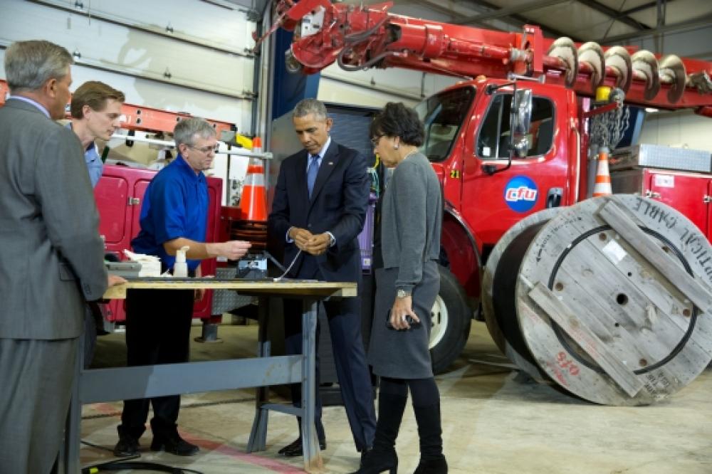 President Barack Obama with Commerce Secretary Penny Pritzker views demonstration of fiber optic spicing at Cedar Falls Utilities in Cedar Falls, Iowa (The White House/Pete Souza)