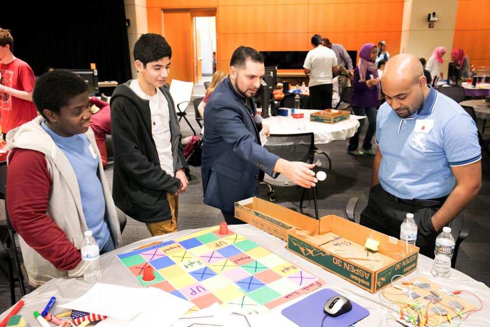 Juan Valentin (center) works with high school students during the U.S. Patent and Trademark Office's  2017 Engineering Week. 
