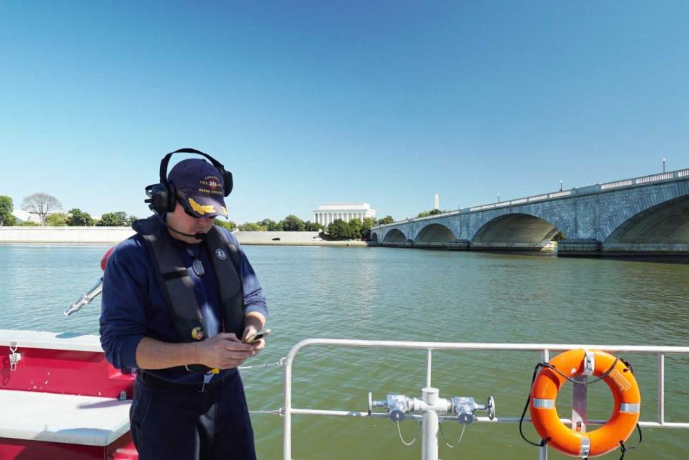 Alexandria (Va.) Fire Captain Phil Perry uses a mobile device while on board a fire boat on the Potomac River