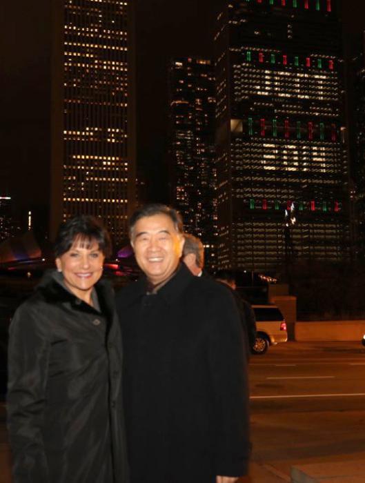 Secretary Pritzker and Vice Premier Yang stand in front of "JCCT 2014" in lights