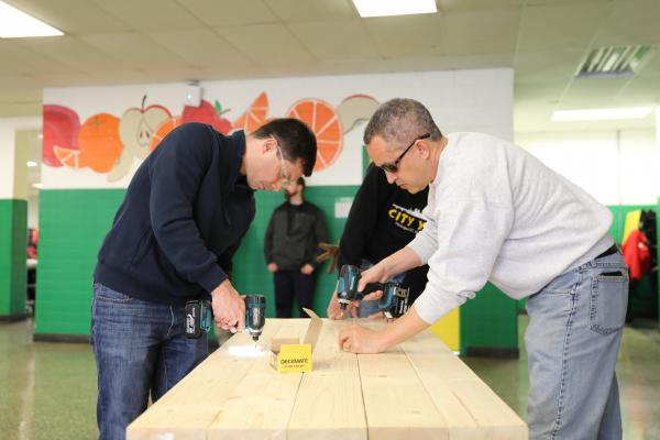 Deputy Secretary Graves Graves and Transportation Secretary Buttigieg help build a table for Hart Middle School in Washington, D.C. 