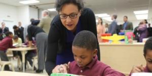 Commerce Secretary Penny Pritzker and a student at the Langdon Education Campus explore a LeapFrog handheld device, the 700,000th design patent awarded by the Unites States Patent and Trademark Office